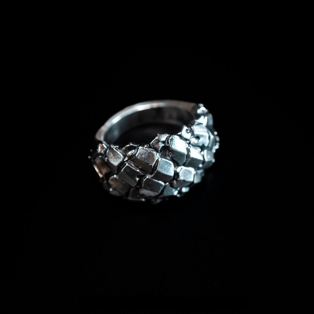 silver ring with abstract flowing plates sculpted across the form