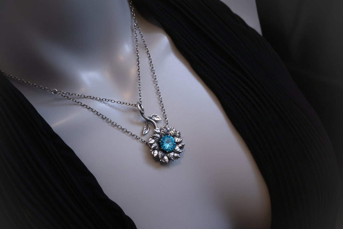 Necklace with a blue gemstone pendant on a mannequin.