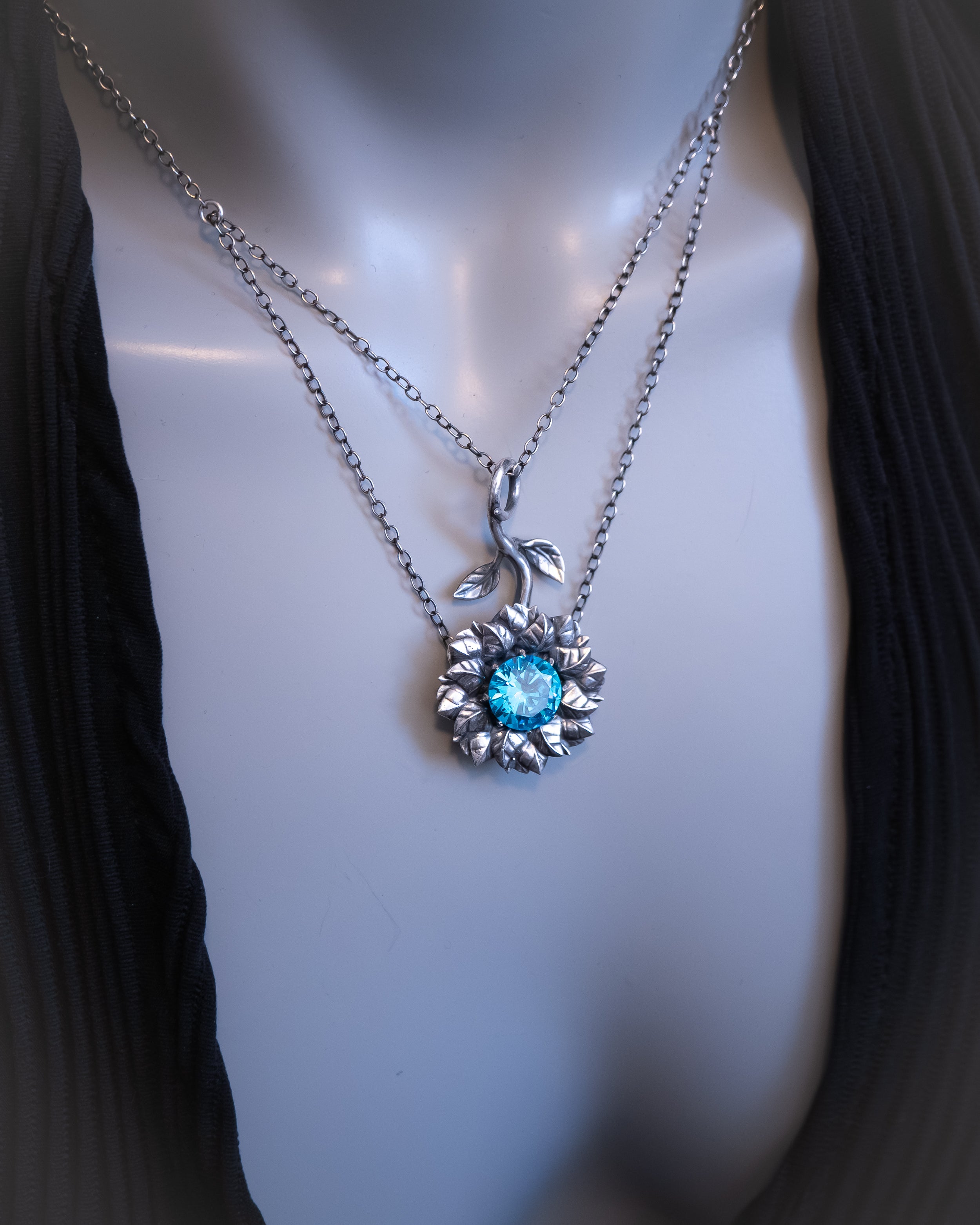 Necklace with a blue gemstone pendant on a mannequin