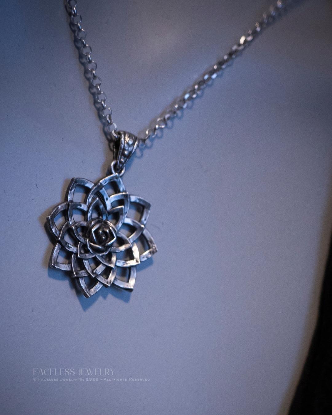 Silver necklace with a flower-shaped pendant on a light blue background