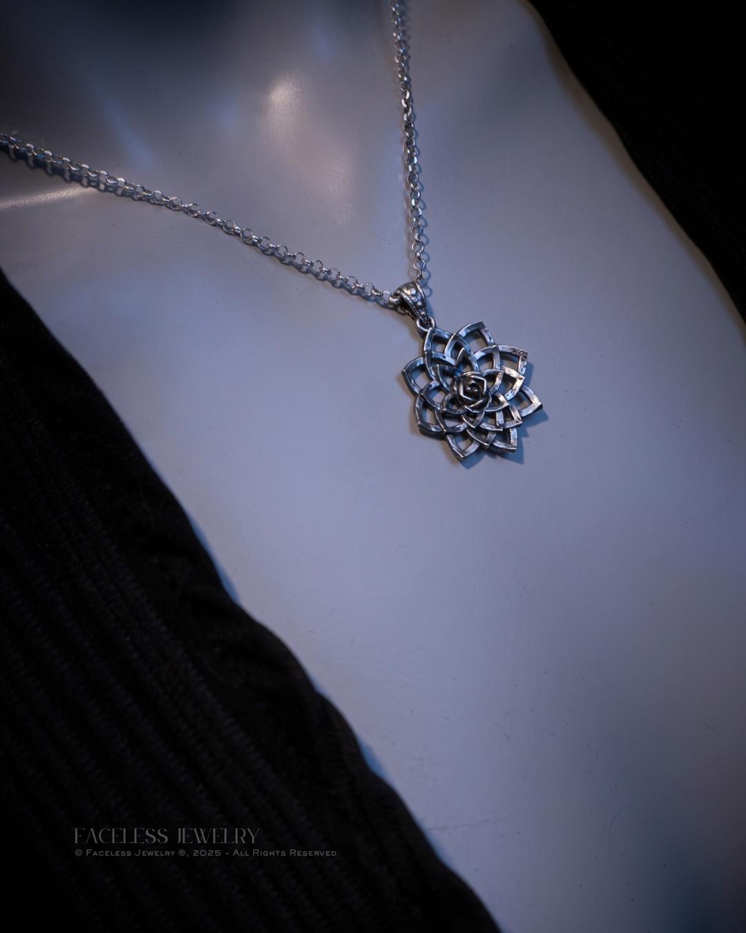 Silver lotus flower necklace on a plain background
