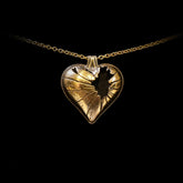 Gold heart-shaped pendant necklace on a black background