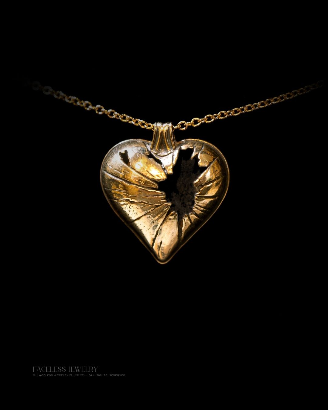 Gold heart-shaped pendant on a chain against a black background