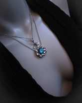 Necklace with a blue gemstone pendant on a mannequin.