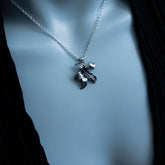 Silver necklace with a leaf pendant on a mannequin