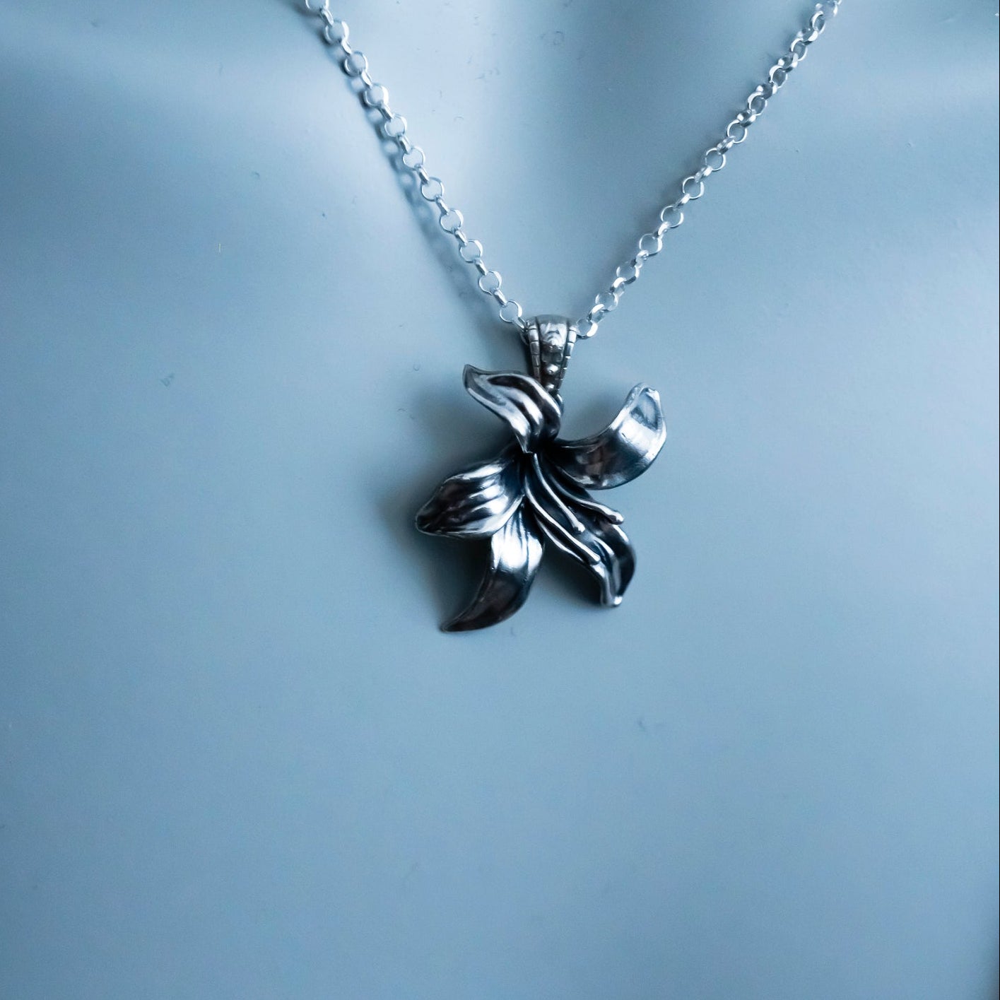 Silver necklace with a butterfly pendant on a light gray background
