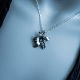 Silver necklace with a butterfly pendant on a mannequin bust.