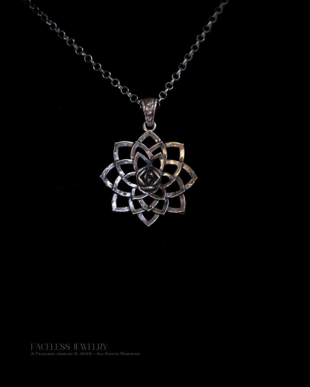 Silver lotus flower pendant on a black chain against a black background