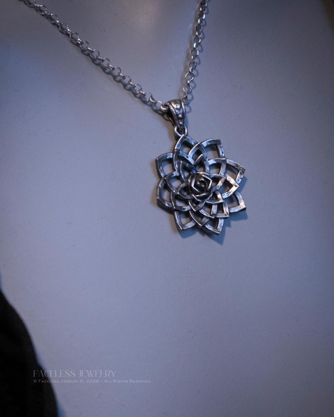 Silver necklace with a intricate pendant on a plain background
