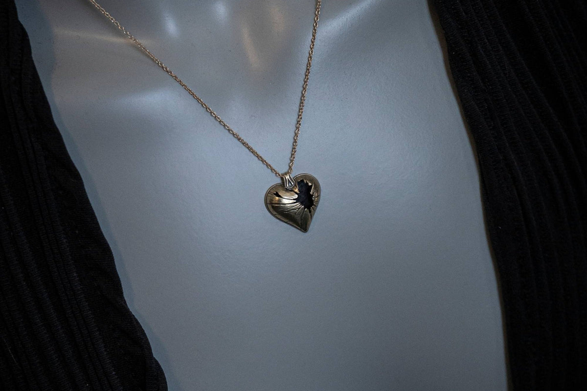 Heart-shaped pendant necklace on a mannequin with a dark background