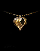 Gold heart-shaped pendant necklace on a black background