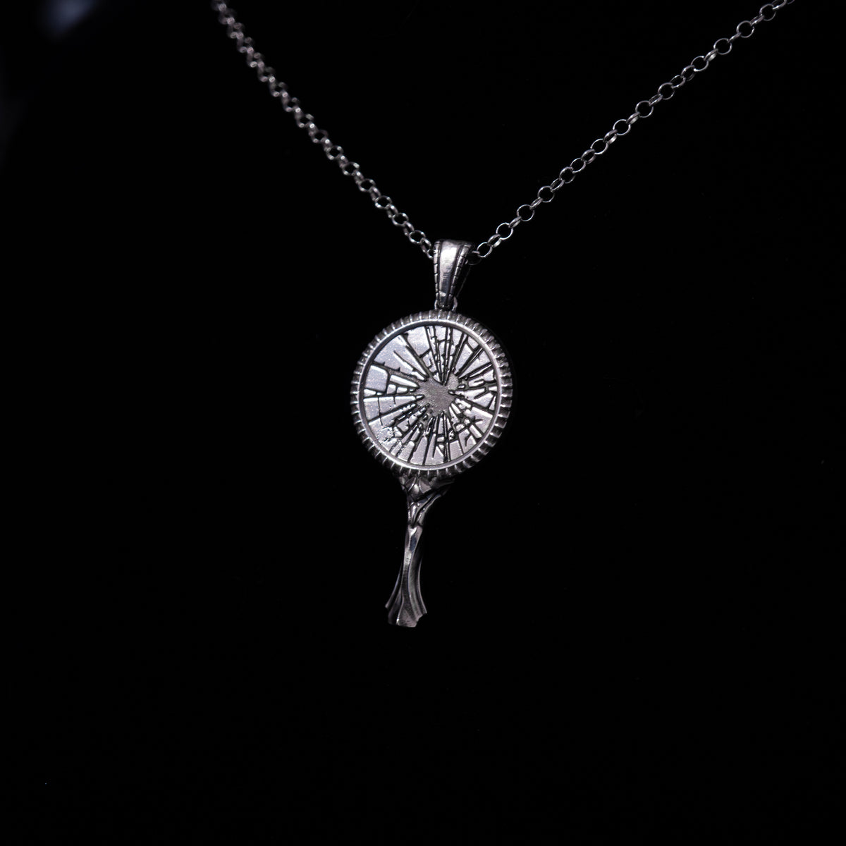 Silver broken mirror pendant necklace on a black background